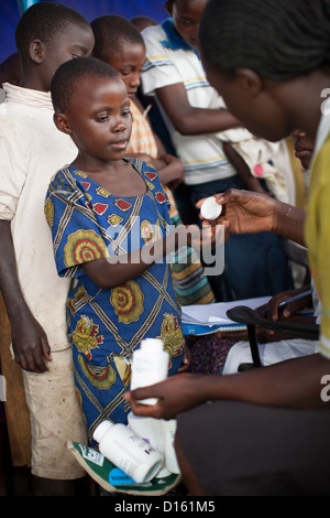 Kinder in die Warteschlange für Entwurmung Medikamente eine Immunisierung Outreach Camp in Kitugutu Dorf, Kyenjojo District, Uganda. Stockfoto