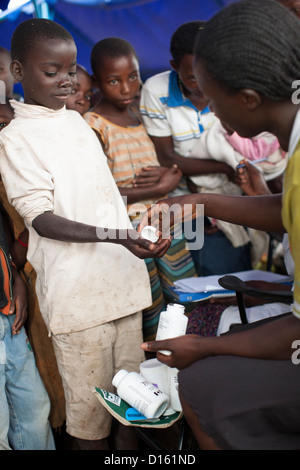 Kinder in die Warteschlange für Entwurmung Medikamente eine Immunisierung Outreach Camp in Kitugutu Dorf, Kyenjojo District, Uganda. Stockfoto