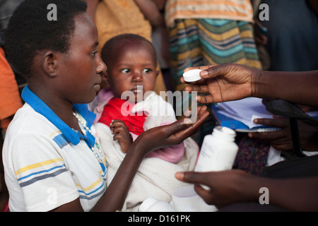 Kinder in die Warteschlange für Entwurmung Medikamente eine Immunisierung Outreach Camp in Kitugutu Dorf, Kyenjojo District, Uganda. Stockfoto