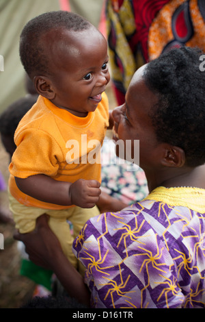 Eine Mutter bringt ihr fünf - Monate alten Sohn zu Immunisierung Outreach Camp in Kitugutu Dorf, Kyenjojo District, Uganda. Stockfoto