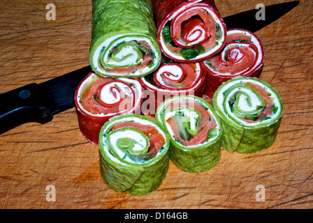 In Scheiben geräucherten Lachs Windräder mit roten Roma Mehl Tomaten & Grüne Spinat Tortillas um Farbe zu geben Stockfoto