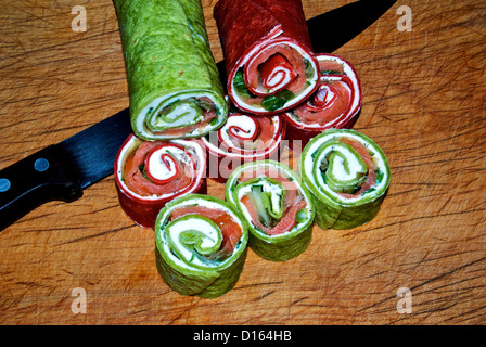 In Scheiben geräucherten Lachs Windräder mit roten Roma Mehl Tomaten & Grüne Spinat Tortillas um Farbe zu geben Stockfoto