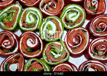 In Scheiben geräucherten Lachs Windrad Vorspeisen mit roten Roma Mehl Tomaten & Grüne Spinat Tortillas um festliche Farbe geben Stockfoto