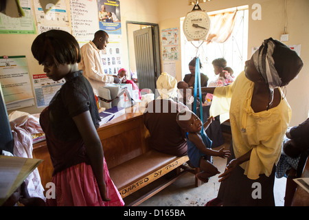 Eine Frau wiegt ihr Kind in ein Gesundheitszentrum auf Bussi Insel, Uganda, Ostafrika. Stockfoto