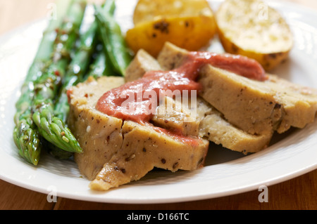 Seitan-Scheiben mit Rhabarber Senf, grünem Spargel und Bratkartoffeln. Stockfoto