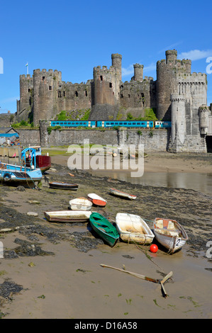 Bahnlinie & historischer Conwy Castle Arriva Zug verlässt Robert Stephenson Eisenbahnbrücke über River Conwy kleine Boote auf Vorschiff Clwyd North Wales UK Stockfoto