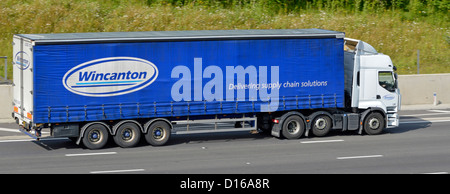 „Wincanton Logo & Supply Chain Solutions“-Schriftzug auf der Seitenansicht des Lkw-Aufliegers und des gelenkten blauen Vorhangwagens auf der Autobahn M25 UK Stockfoto