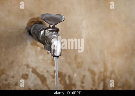 Alten Wasserhahn an der Betonwand Stockfoto