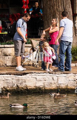 Kleines Mädchen am San Antonio Riverwalk Enten füttern. Stockfoto