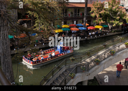 Binnenschiff befördert Touristen entlang des San Antonio River durch die Innenstadt Riverwalk in San Antonio, Texas. Stockfoto