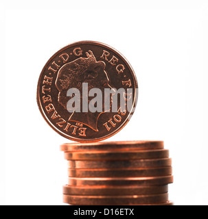 Britische one Penny dezimale Münze balanciert auf Haufen von Münzen Stockfoto