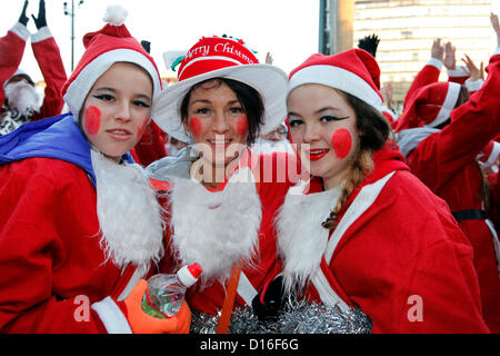 Glasgow, Schottland. Sonntag, 9. Dezember 2012. Santa Dash Charity Fun Run.  Angela Brown, Mutter und Tochter Jordan McEwan, im Alter von 13, rechts, und ihre Freundin Emma Glen, im Alter von 12, links, zu Beginn der Santa Dash gesponsert von der Daily Record. Alle sind aus Glasgow. Alamy Live-Nachrichten Stockfoto