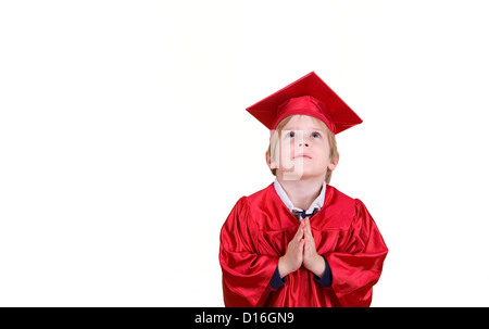 Ein kleiner Junge sucht mit seinen Händen in ein Gebet Position trägt eine Mütze und Mantel. Stockfoto