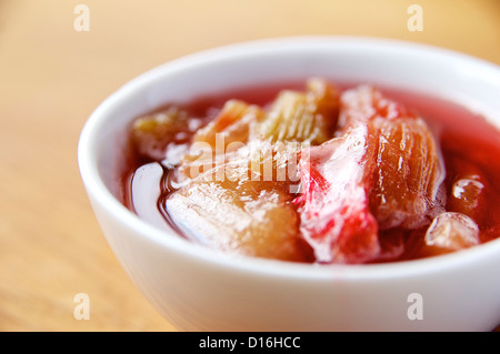 Rhabarberkompott in einer kleinen Schüssel auf ein Kokos-Kuchen mit Rhabarber serviert werden. Stockfoto