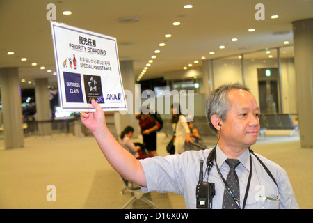 Tokio Japan, Narita International Airport, NRT, Gate, ANA, Al Nippon Airways, asiatischer Mann Männer Erwachsene Erwachsene, Uniform, halten, Schild, Priority Boarding, Englisch Stockfoto