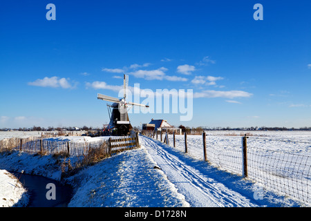 Holländische Windmühle und Bauernhaus im Schnee im winter Stockfoto