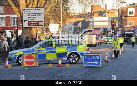 Turnpike Lane, London, UK. 10. Dezember 2012. Ein Polizei-Auto und Verkehrszeichen in der Nähe der Unfallstelle am Turnpike Lane.  Die Szene des Unfalls auf Green Lanes sind außen Turnpike Lane Station, Polizei und Verkehr Offiziere anwesend. Green Lanes ist geschlossen verursachen Staus zu Verkehr und Buslinien. Die Fußgänger, die in ihren 30ern ist, wurde nach der Kollision kurz nach 07:00 Royal London Hospital in Whitechapel mit vermuteten Kopfverletzungen gehetzt.   Zwei Krankenwagen, zwei Sanitäter Autos und eine Luft-Krankenwagen-Crew in einem Auto genannt wurden, um die Szene zu den Patienten zu behandeln. " Stockfoto