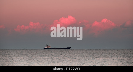 Abendrot über Meer mit Schiff am Horizont Stockfoto