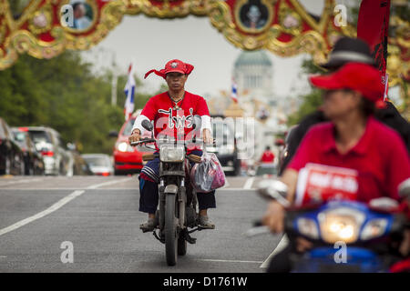 10. Dezember 2012 - Bangkok, Thailand - A Red Shirt Demonstranten reitet sein Motorrad an der Ratchadamnoen Avenue in Bangkok Montag. Die thailändische Regierung kündigte am Montag, dem Tag der Verfassung in Thailand ist, die ihre Kampagne, eine neue Charta schreiben beschleunigen wird. Dezember 10 markiert Übergang der erste dauerhafte Verfassung im Jahr 1932 und Thailands Übergang von einer absoluten Monarchie zu einer konstitutionellen Monarchie. Mehrere tausend '' Red Shirts,'' Anhänger des gestürzten und im Exil lebenden Premierminister Thaksin Shinawatra, motorcaded durch die Stadt, Halt an Regierungsstellen und die Büros der Pheu Th Stockfoto