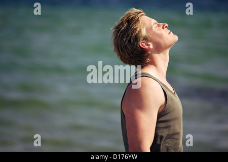 Junger Mann im Urlaub genießen Sie die frische Meeresbrise Stockfoto