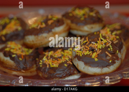 Mini-Schokoladen-Donuts mit Orangenstreuseln. Stockfoto