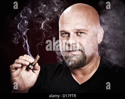 glatzköpfiger Mann mit einem Bart raucht eine Zigarre Stockfoto