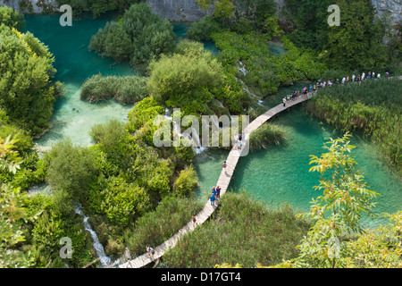 Touristen zu Fuß entlang Holzstege im Nationalpark Plitvicer Seen in Kroatien. Stockfoto