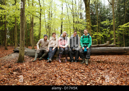 Lächelnden Freunde sitzen melden Sie sich im Wald Stockfoto