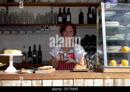 Frau in Schürze arbeiten im café Stockfoto