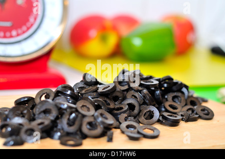 Entsteinte olivenscheiben schwarze auf ein Schneidbrett aus Holz Stockfoto