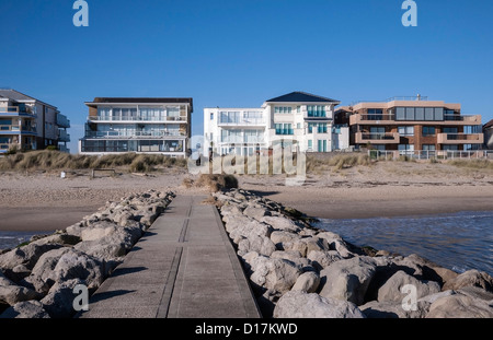 Blick auf Luxus Apartments von einem groyne auf Sandbänken Strand, Bucht von Poole, Dorset, England, UK. Europa Stockfoto