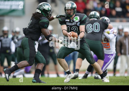 QB Thomas Haider (#13 Drachen) übergibt den Ball an RB Tunde Ogun (#1 Drachen) am 31. März 2012 in Wien, Österreich. Stockfoto