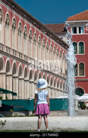 Junges Mädchen und Brunnen in Prokurative (aka Platz der Republik), ein Platz in der Stadt Split an der kroatischen Adria Küste. Stockfoto