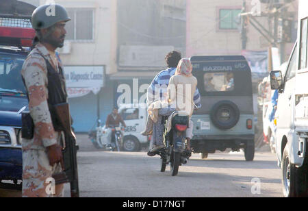 Offizielle Ranger steht Warnung während gezielte Suchaktion gegen Terroristen und Schurken auf Mehmoodabad Gebiet in Karachi auf Montag, 10. Dezember 2012. Nach Sicherheitskräfte Rangers einen gezielten Suchauftrag in Mehmoodabad, Pak-Kolonie und den angrenzenden Gebieten durchgeführt und mindestens 22 Verdächtige festgenommen.  Die festgenommenen Verdächtigen gehören drei lokale Amtsträger der politischen Parteien. Die Sicherheitskräfte, die Teilnahme an der Operation auch behauptet, dass Waffen und Munition während des Überfalls eingezogen worden sind Stockfoto