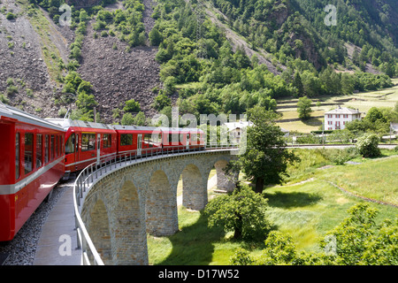 Schweizer Bergbahn Bernina Express führt die Spirale von Brusio Viadukt Stockfoto