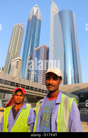 Dubai VAE, Vereinigte Arabische Emirate, Sheikh Zayed Road Asiatische Männer Wanderarbeiter, Immigranten Bangladeshi Hochhäuser Wolkenkratzer Gebäude Türme Stockfoto