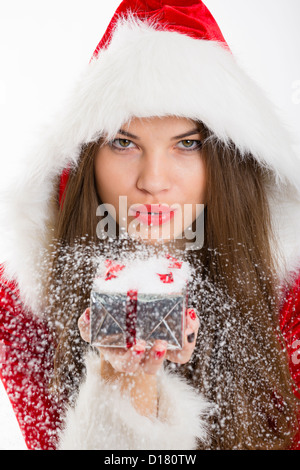 Porträt von schönen Santa Mädchen Schneetreiben aus Silber Weihnachts-Geschenk-Box in der Hand. Stockfoto