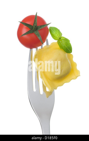 Ravioli Pasta Tomaten und Basilikum auf einer Gabel vor weißem Hintergrund Stockfoto