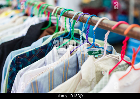 Altes Hemd hängen, Kunststoff-Aufhänger in Second Hand Markt Stockfoto