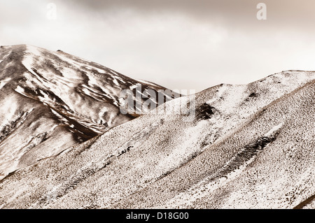 Grass und Schnee an Berghängen Stockfoto