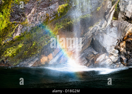 Regenbogen im Wasserfall über Klippen Stockfoto