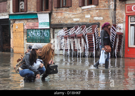 Zwei junge Mädchen fotografieren während der "Acqua Alta" überschwemmen. Stockfoto