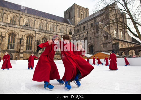 Kathedrale von Winchester, Hampshire, England, UK.11.12.2012 Bild zeigt junge Choristers der Winchester Cathedral Schlittschuhlaufen auf der Kathedrale-Eisbahn, im Rahmen der jährlichen Feierlichkeiten zu Weihnachten gelaufen. Stockfoto