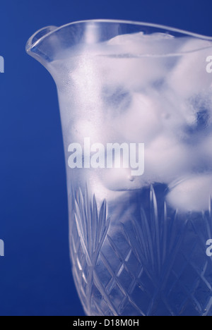 Saubere klare Eiswasser in Glaskanne auf blauem Hintergrund Stockfoto