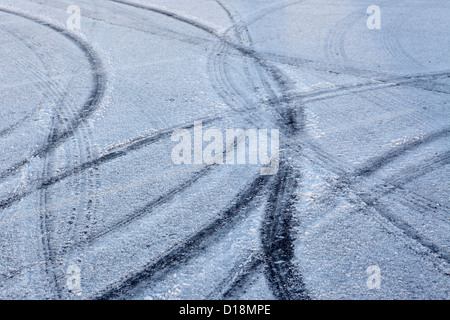 Reifenspuren auf eisigen frostigen Schnee unbehandelten Straßenbeläge, Winter einfrieren Wetter Sicherheit im Straßenverkehr, UK. Stockfoto