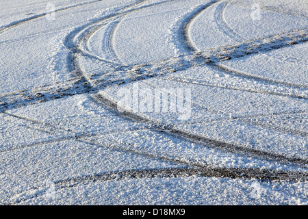 Reifenspuren auf eisigen frostigen Schnee unbehandelten Straßenbeläge, Winter einfrieren Wetter Sicherheit im Straßenverkehr, UK. Stockfoto