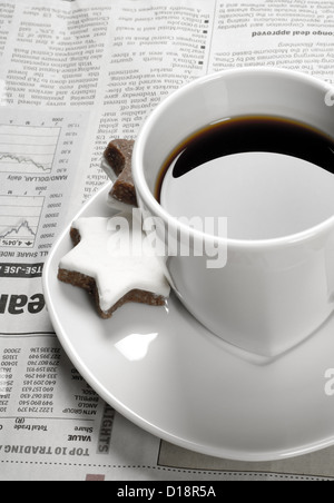 Schwarzen Kaffee auf Finanzzeitung und Star geformt Kekse Stockfoto
