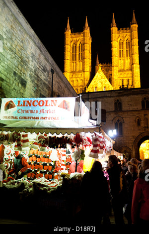 Der jährliche Weihnachtsmarkt in Lincoln, England, UK. Bild zeigt einen Hut Stand mit Blick auf die Kathedrale von Lincoln hinter. Stockfoto