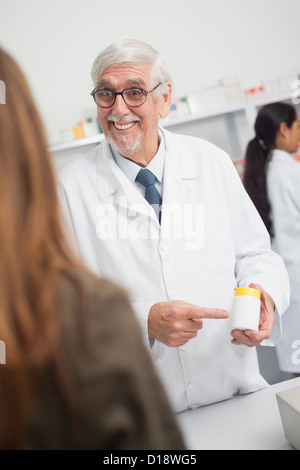 Lächelnde männlichen Apotheker zeigt auf Drogen Stockfoto