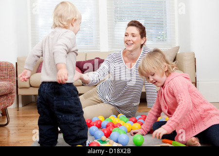 Mutter und Kinder spielen mit Plastikbällen Stockfoto
